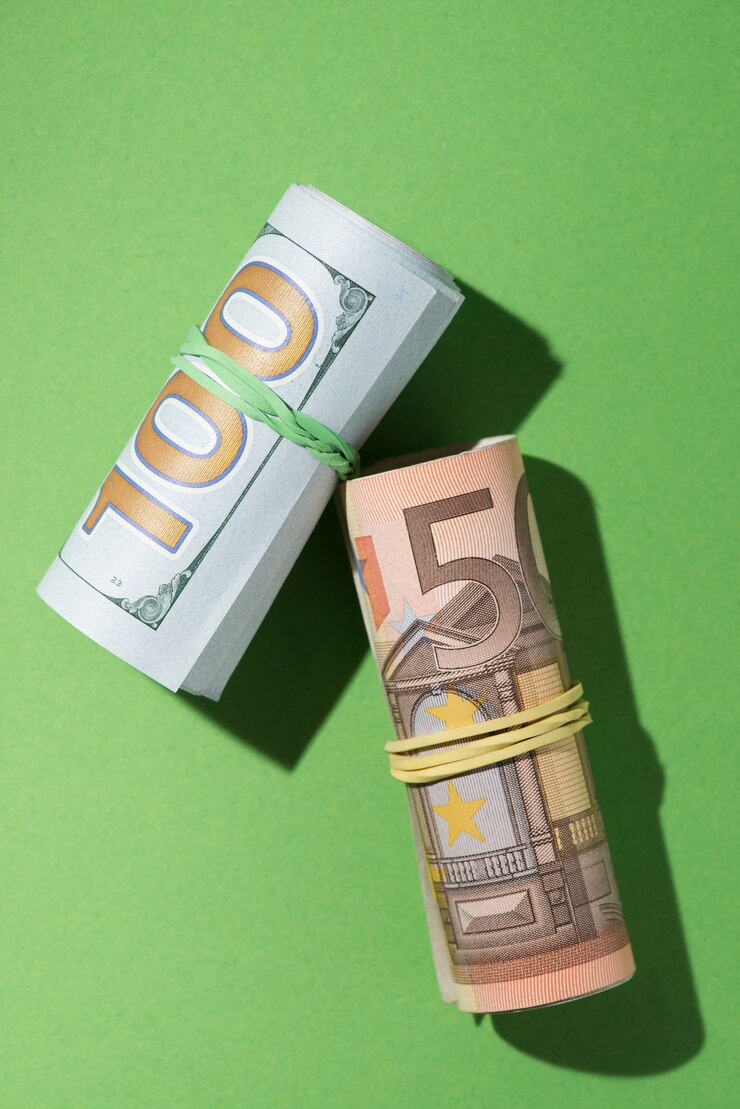 Rolled bundles of U.S. dollars and euro banknotes placed on a bright green background, symbolizing global currency exchange, international trade, and financial stability.