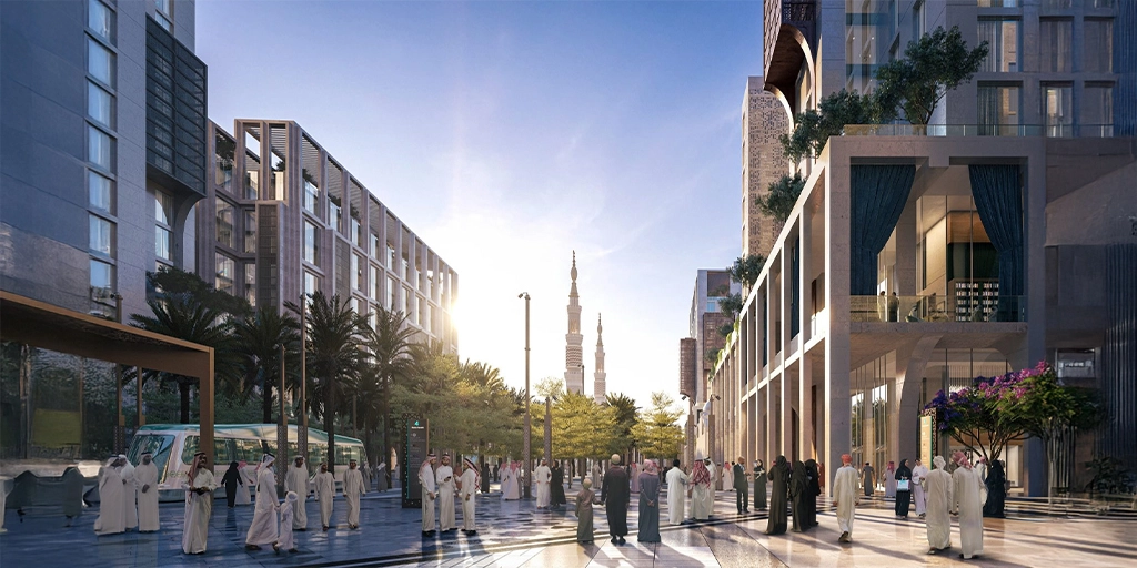 Modern urban development in Saudi Arabia with people walking through a sunlit plaza surrounded by contemporary architecture, representing Vision 2030’s focus on sustainable city planning and community growth.