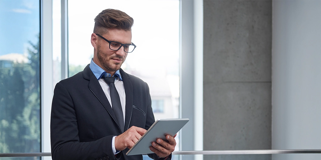 Confident businessman using a digital tablet in a modern office, representing MENA real estate market growth, investment insights, and professional financial analysis.